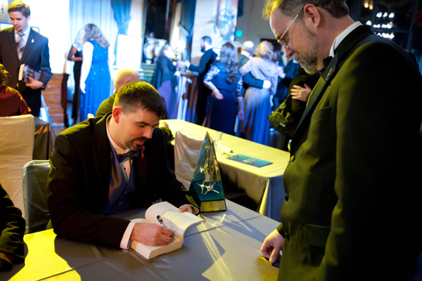 Daniel signing a copy of Writers of the Future Volume 31 at the Annual Awards after-event party.